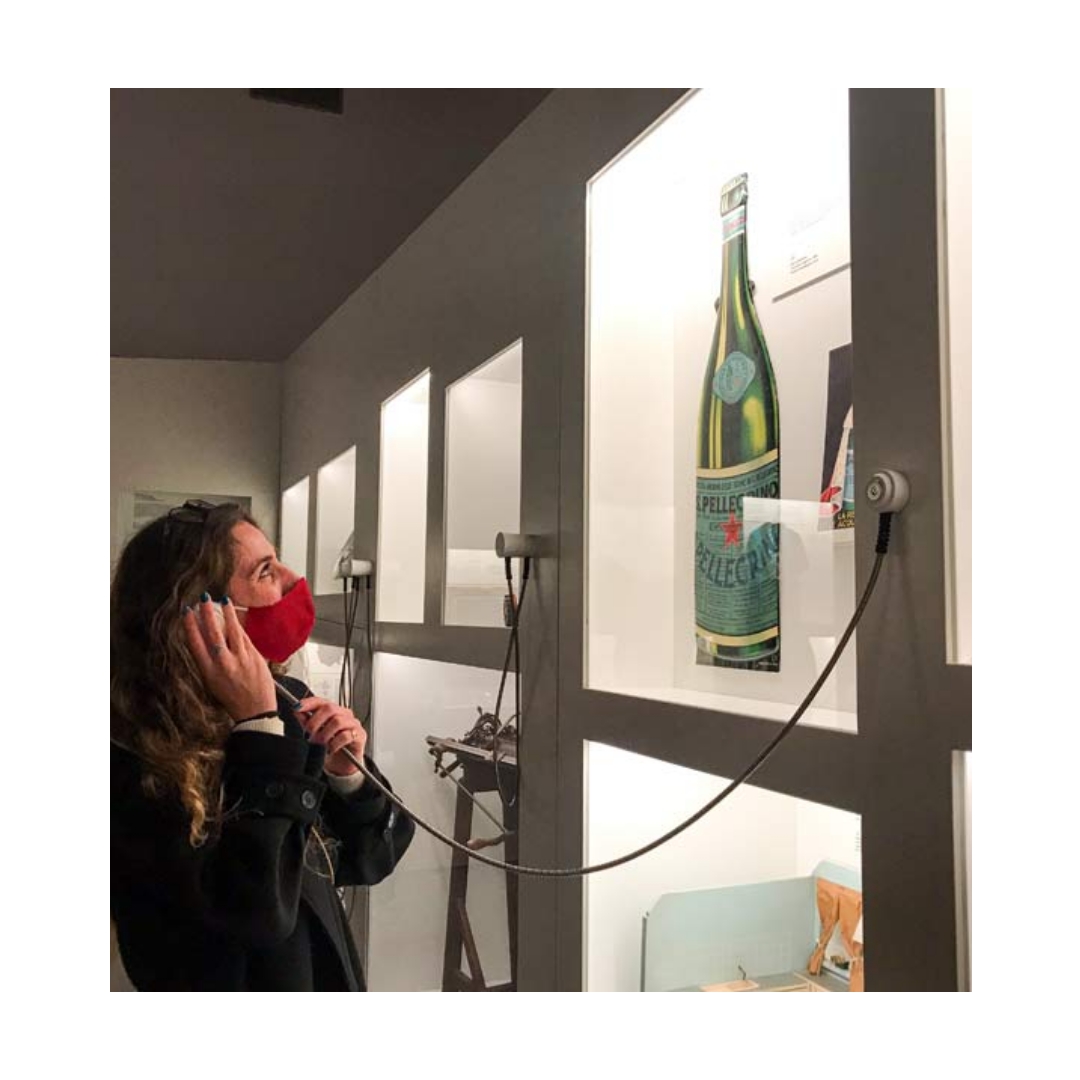 una visitatrice del museo ascolta un audio da un auricolare che fa riferimento ad un pezzo della collezione del museo