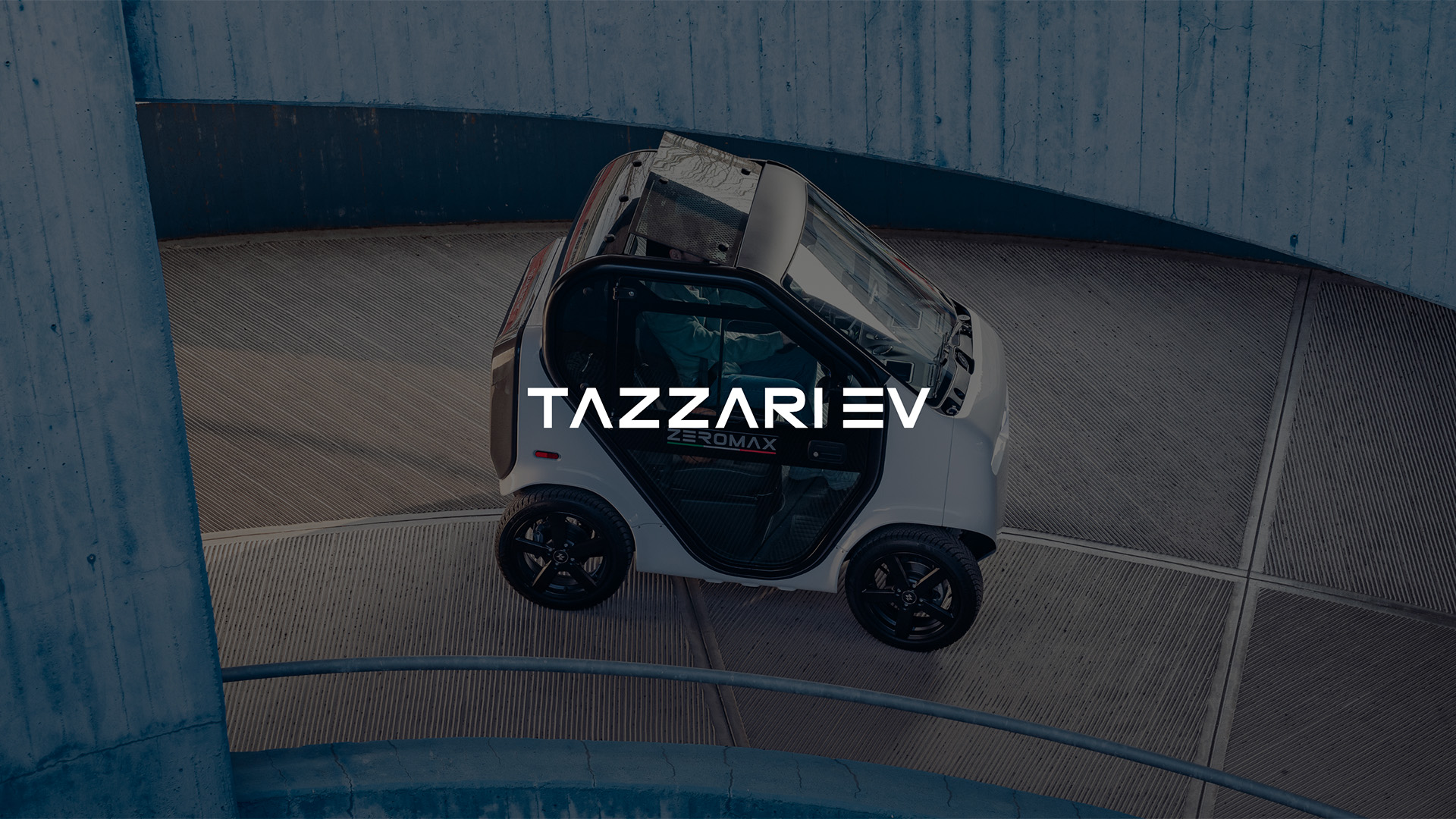 ripresa dall'alto di autoveicolo elettrico marca Tazzari modello Zero Max bianco e nero su rampa di discesa del garage