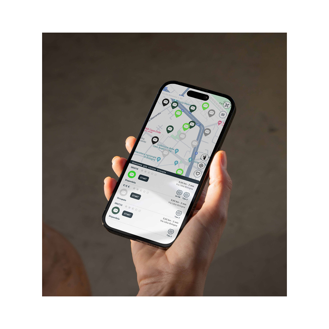 mano che tiene uno smartphone con mappa dei punti di ricarica NextCharge