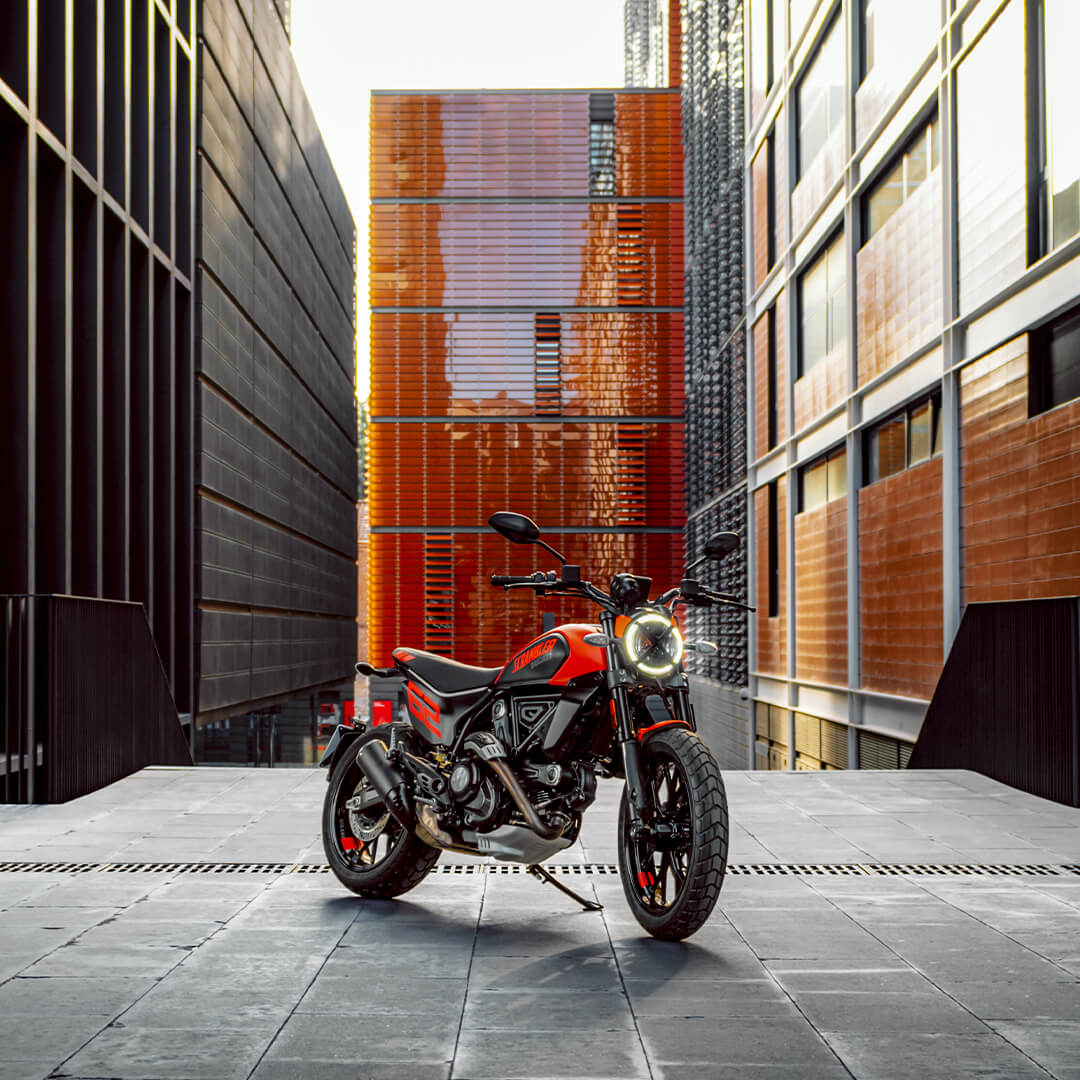 una ducati scrambler rossa su sfondo futuristico